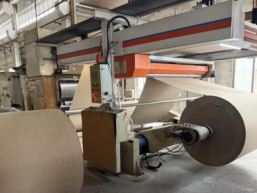 Kraft web running through the laminating line between two parent rolls